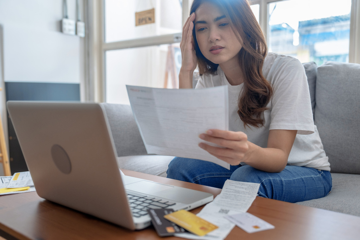 Young Asian woman stressed when she saw the expenses on her bill, Financial problems, Indebtedness, Lose a job.